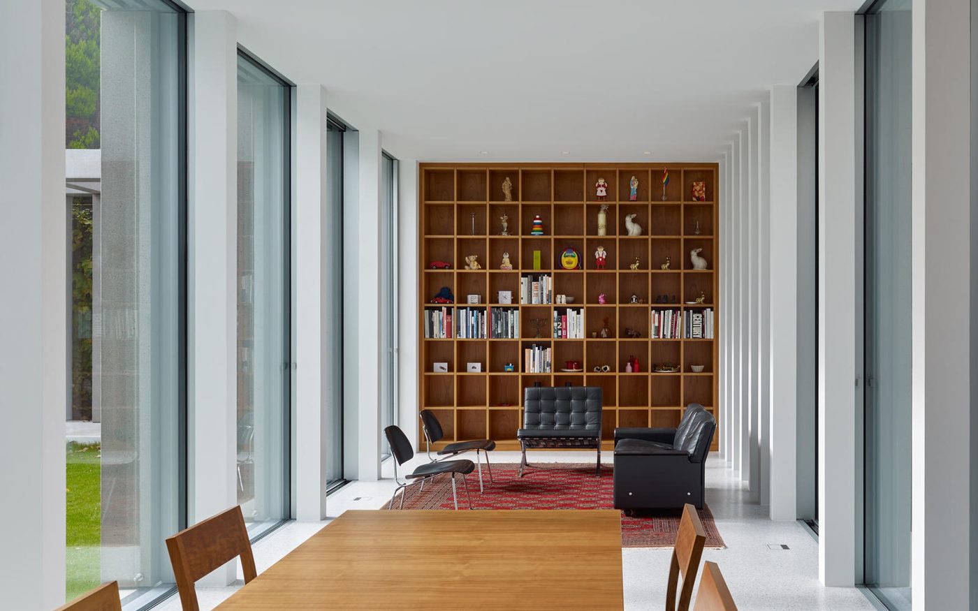 Gartenzimmer mit Esstisch und raumhohem Bücherregal